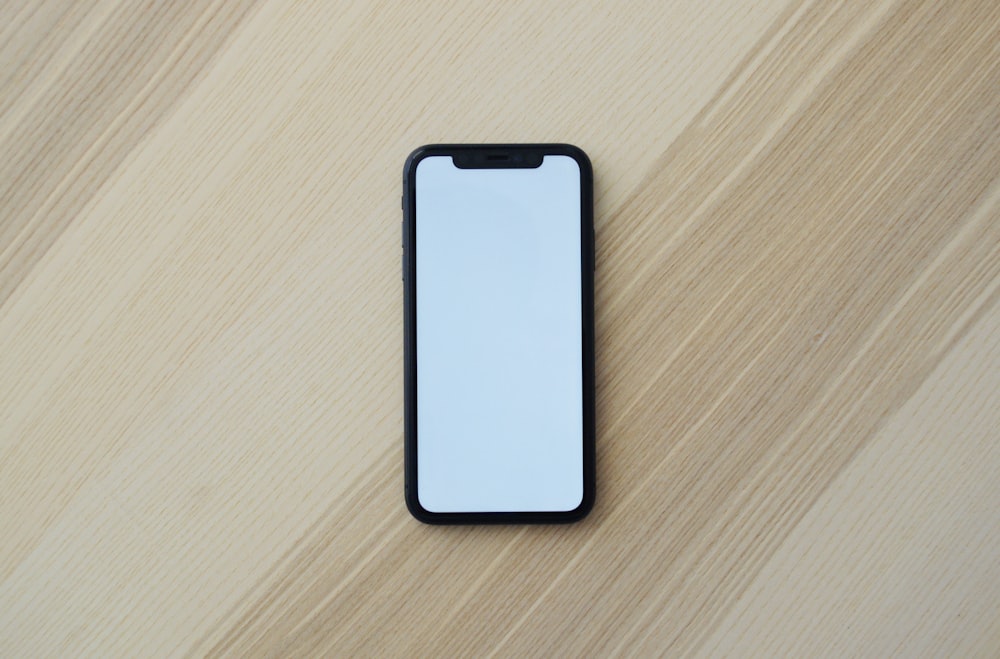 white smartphone on brown wooden table