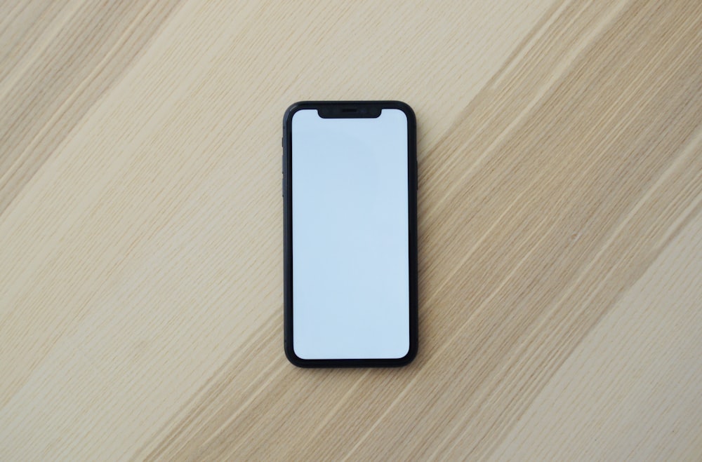 Smartphone blanc sur table en bois marron