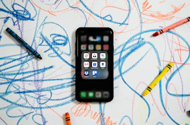 black iphone 4 on white and blue textile