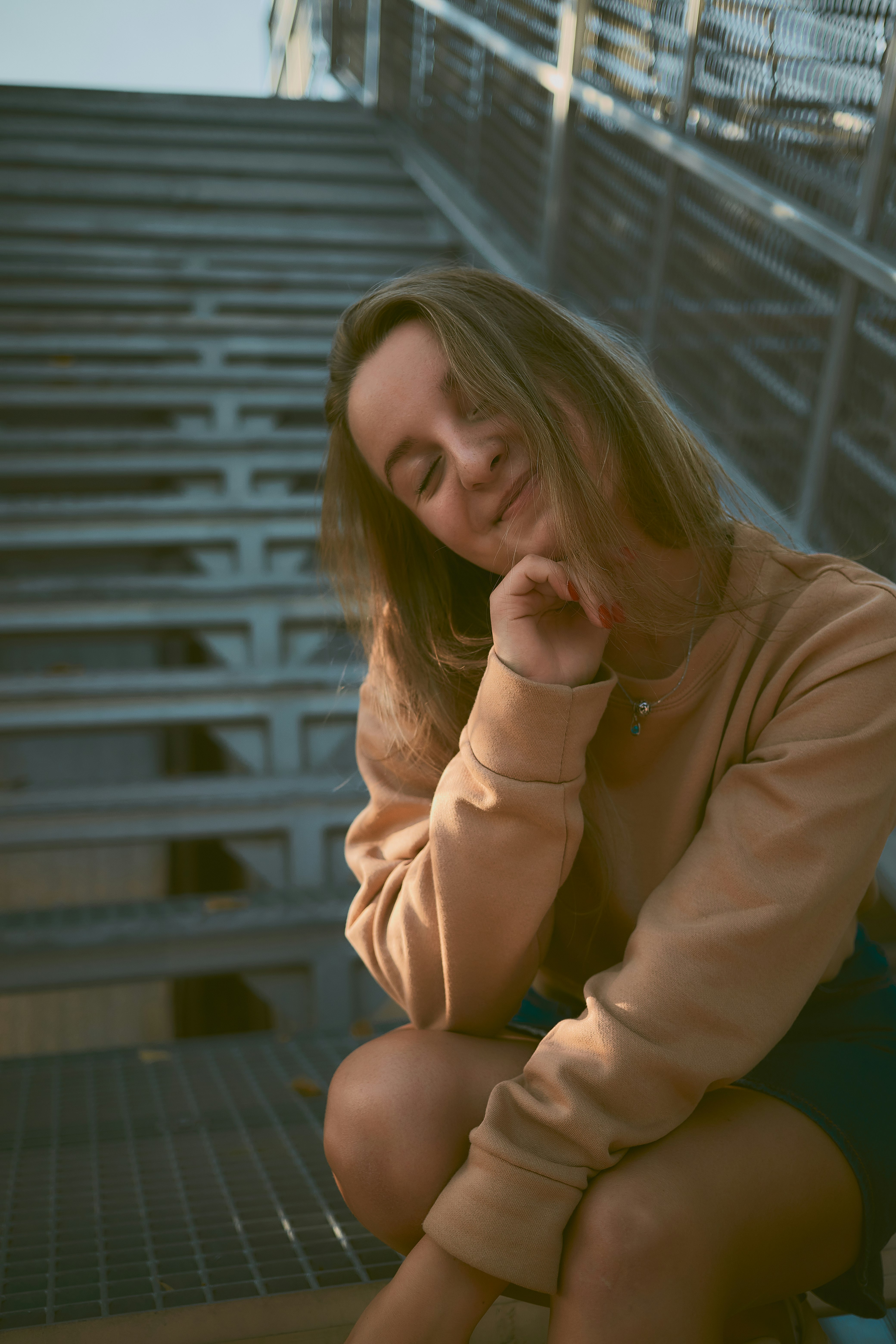 woman in brown long sleeve shirt sitting on brown wooden bench