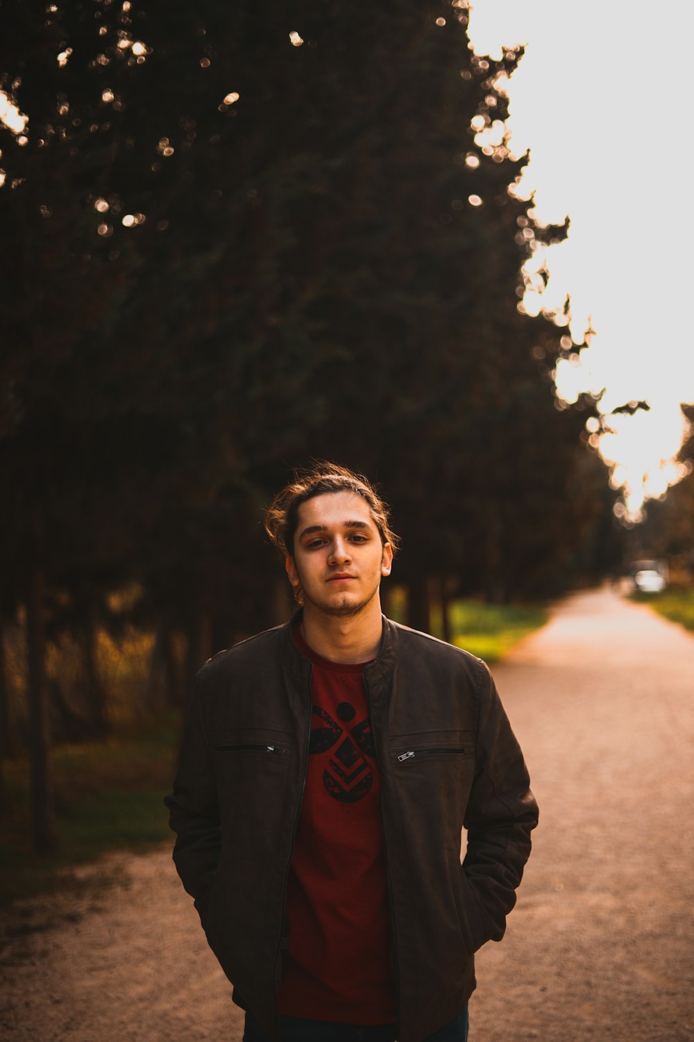 man in black jacket standing on road during daytime