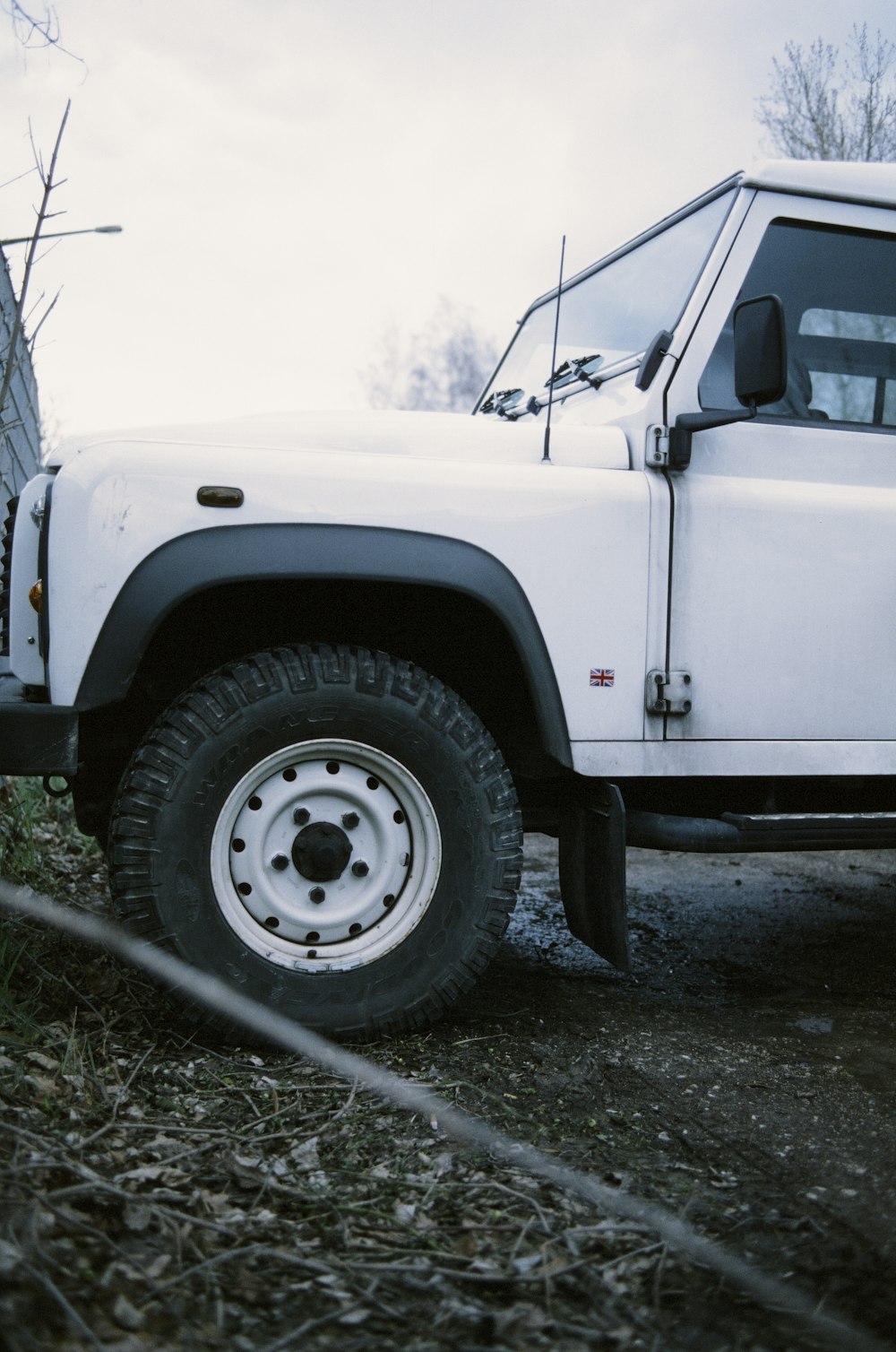 Jeep Wrangler blanche sur un chemin de terre pendant la journée