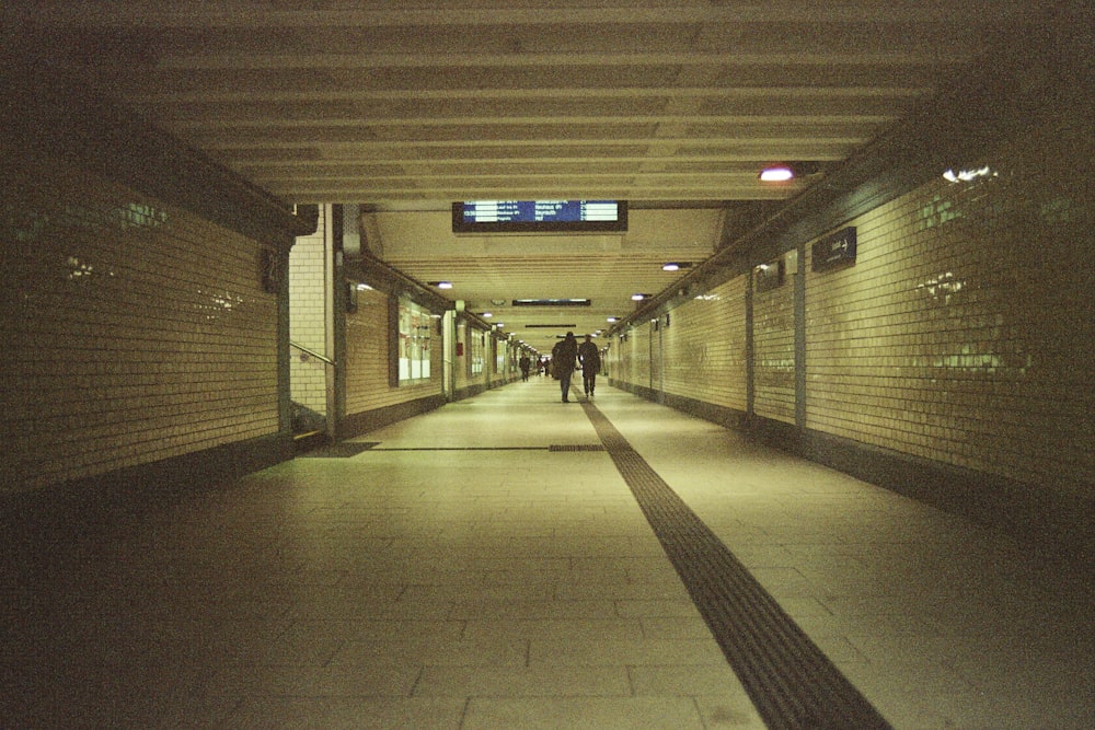 Hombre con chaqueta negra caminando por el pasillo
