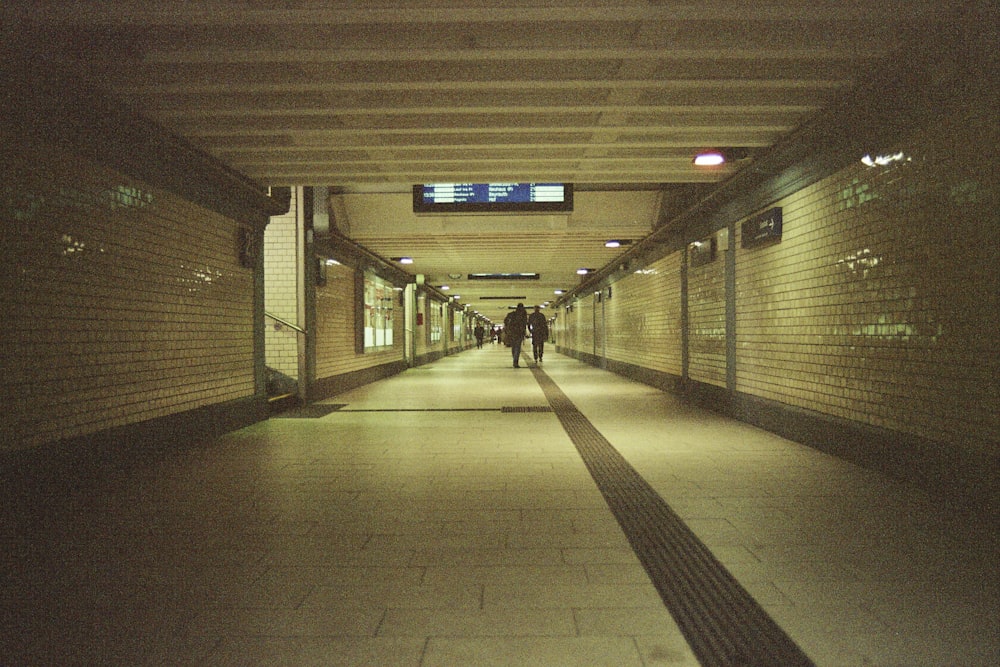 man in black jacket walking on hallway