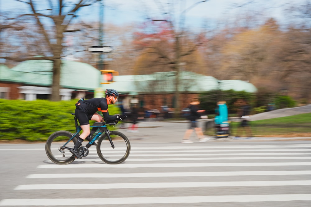 man in green jacket riding bicycle on road during daytime