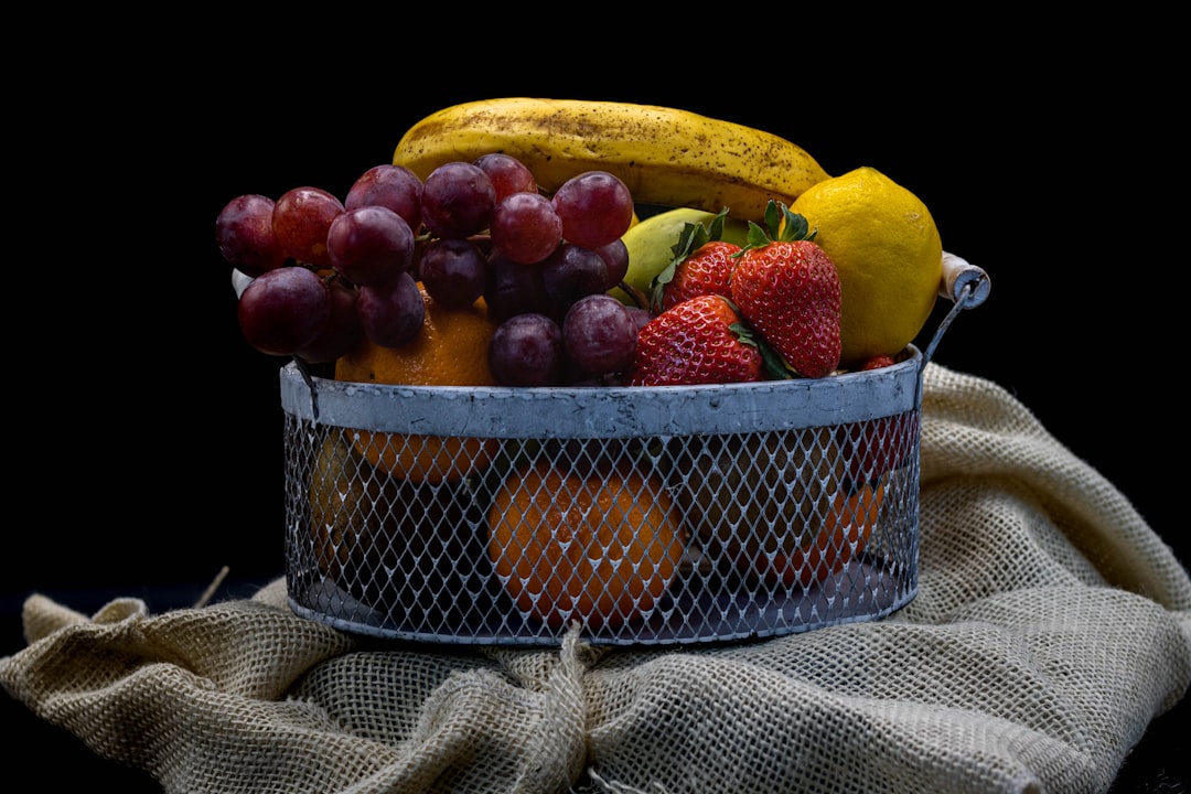 red apples and yellow bananas on stainless steel basket