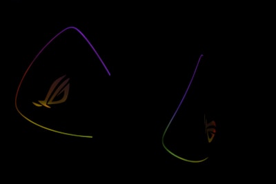 Dark background is highlighted by glowing outlines of colorful triangular shapes with the letters 'ROG' subtly visible, suggesting a gaming or tech-related theme.