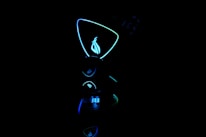 Close-up of glowing neon blue and gold tech gadgets displayed on dark background.