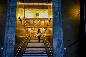 A library exit gate with a security arch and a person walking through with a book.