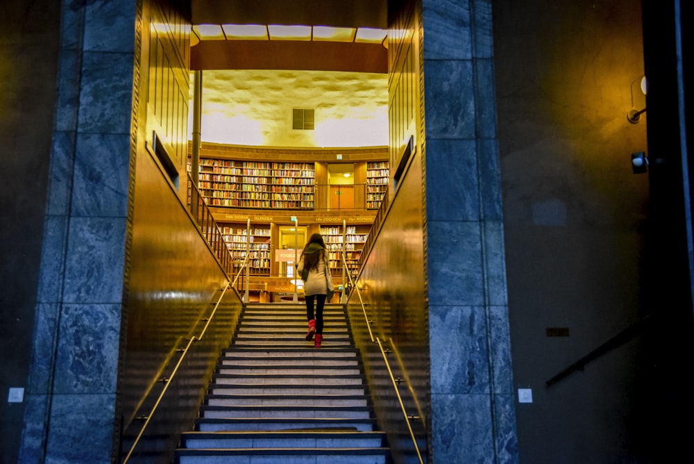 woman in white shirt walking on gray concrete staircase