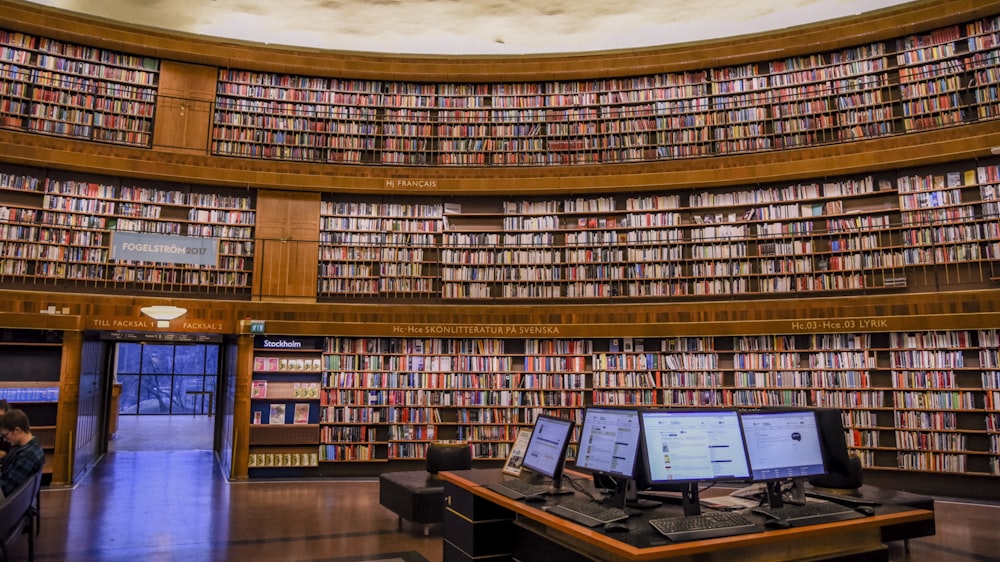 brown wooden book shelves in library