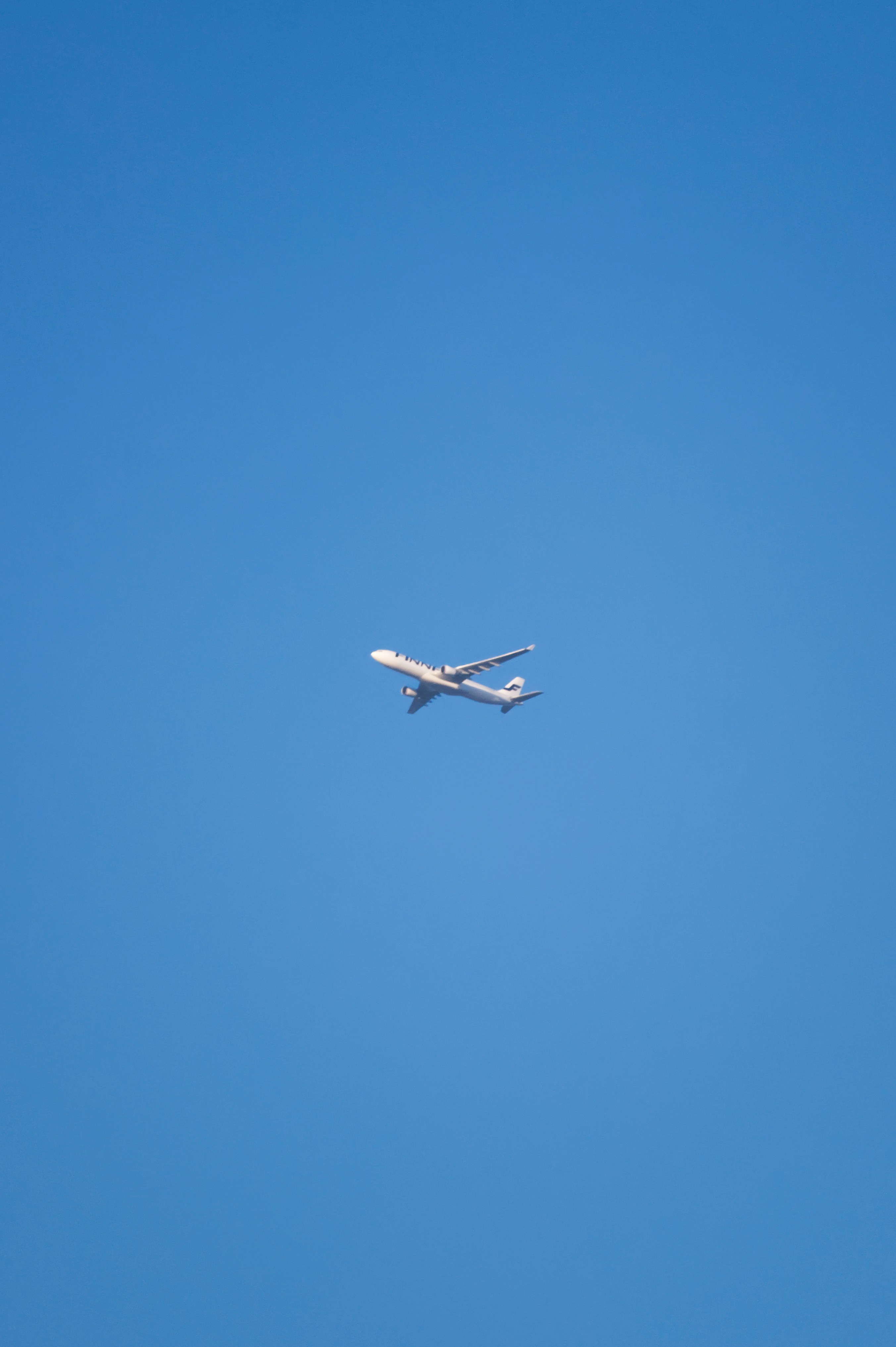 white airplane in mid air during daytime