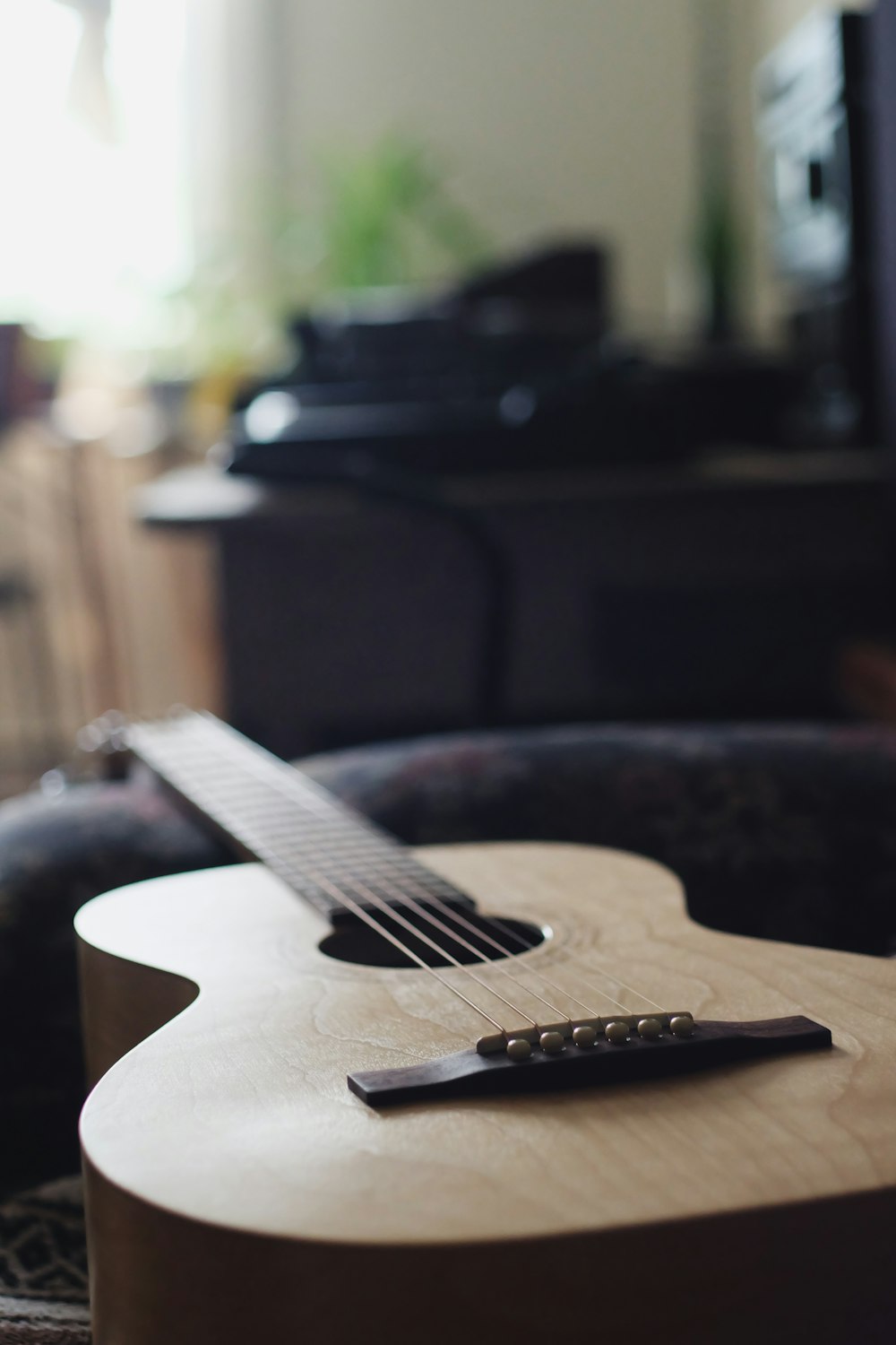 brown acoustic guitar on black chair