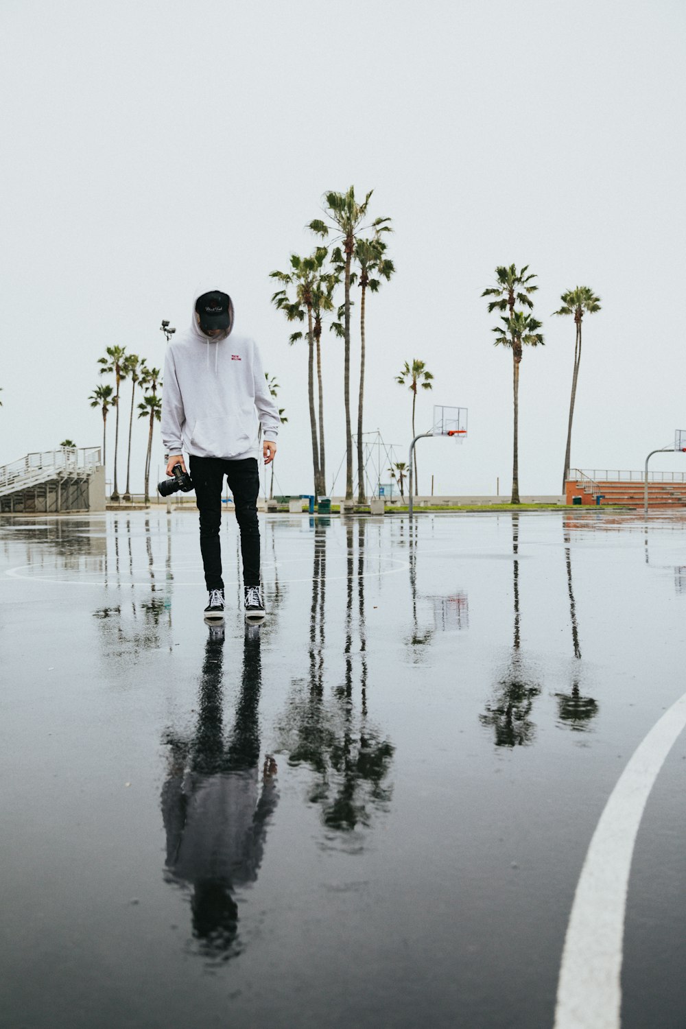 man in white dress shirt and black pants standing on wet ground during daytime