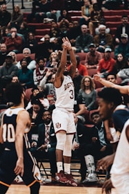 Close-up of a basketball player making a dynamic slam dunk in a packed arena.