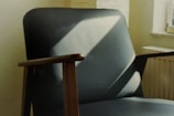 Modern wooden chair with clean lines placed in a muted, natural light setting.