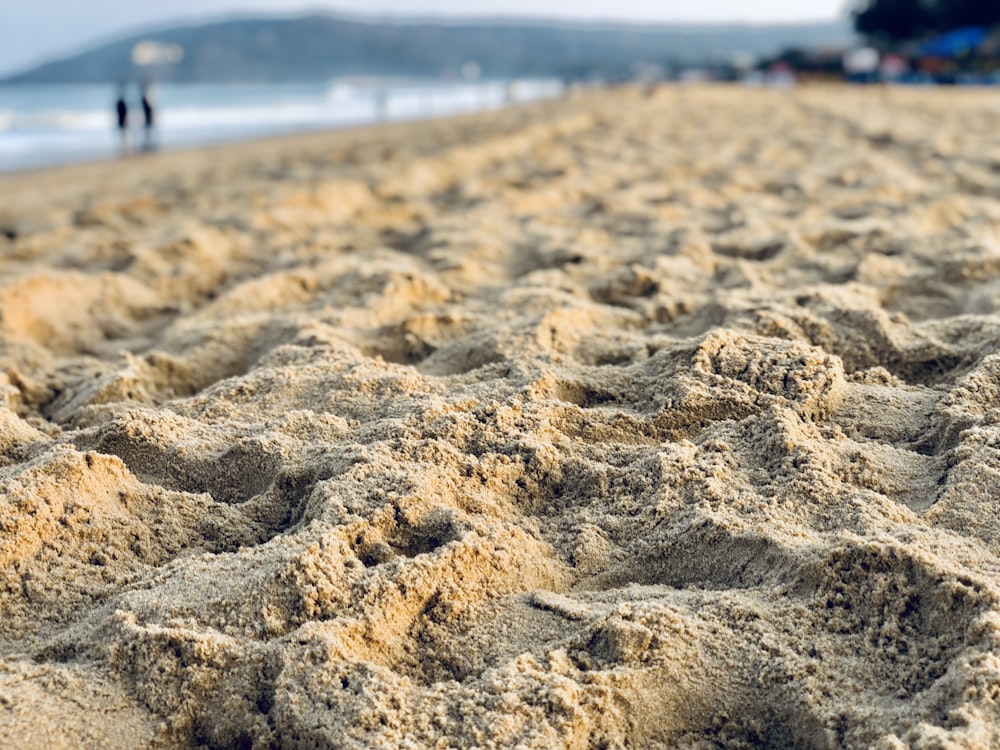 brown sand near body of water during daytime