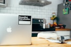 A vibrant kitchen scene with fresh ingredients and a laptop showing a healthy recipe guide.