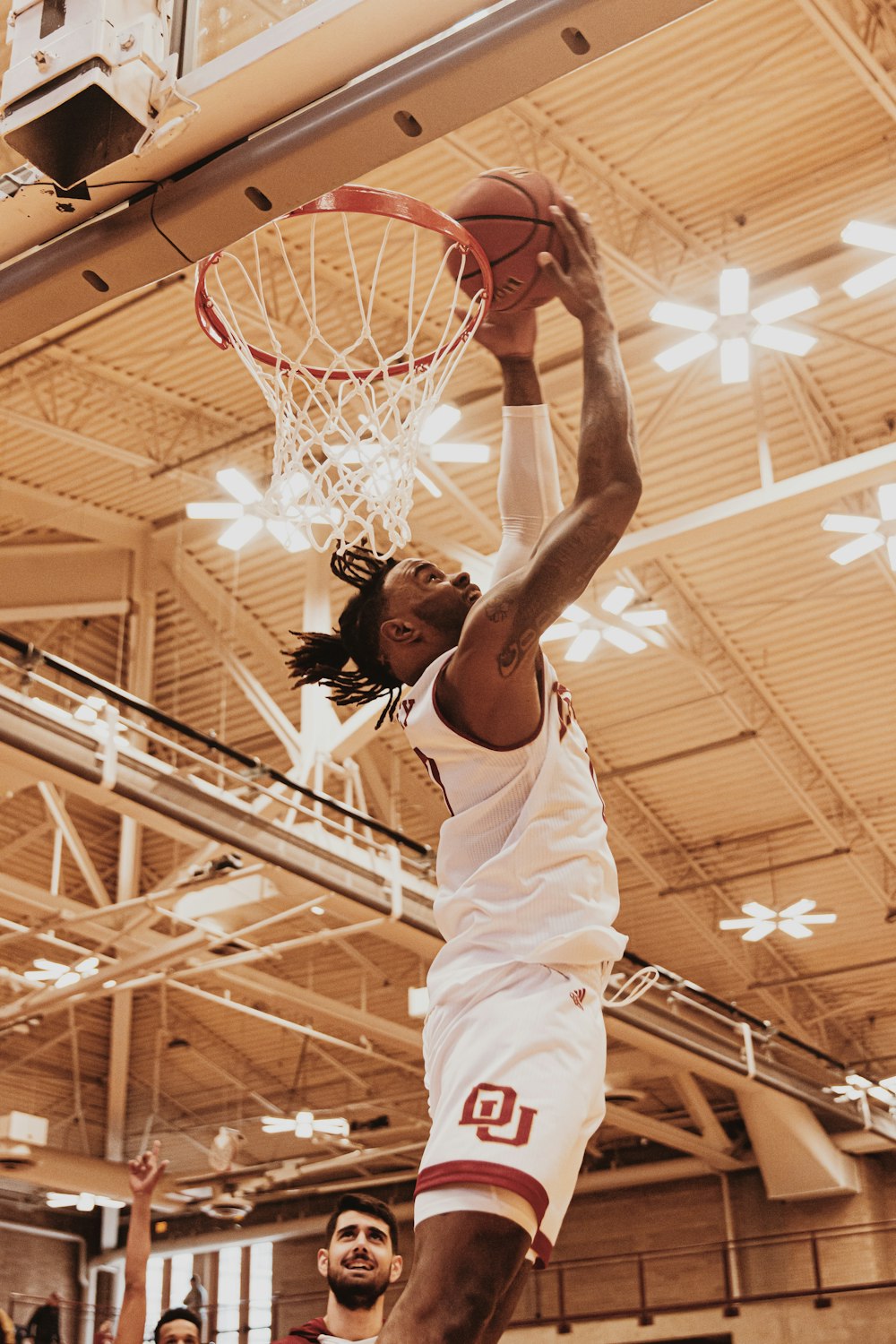 man in white tank top playing basketball