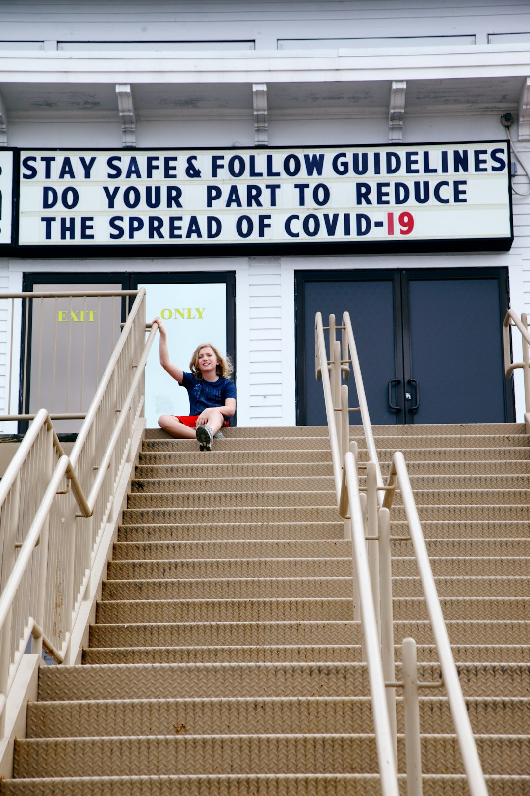 woman in blue t-shirt sitting on stairs