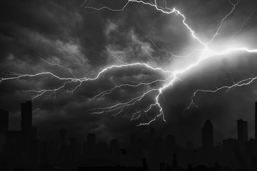 grayscale photo of city buildings under cloudy sky