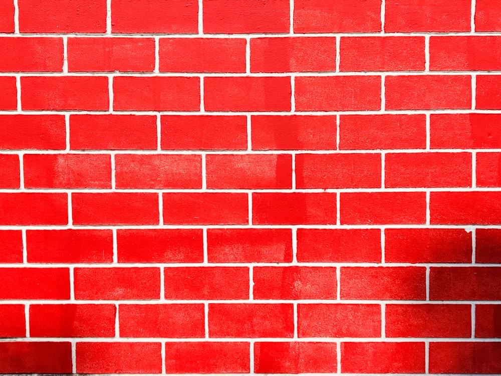 parede de tijolo vermelho durante o dia