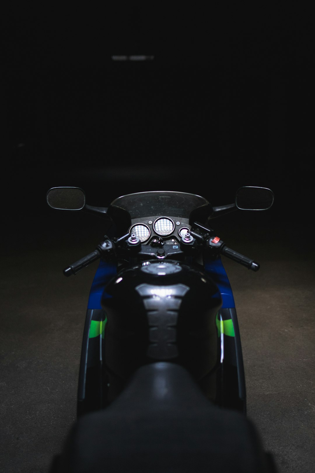 black and green motorcycle on gray concrete floor