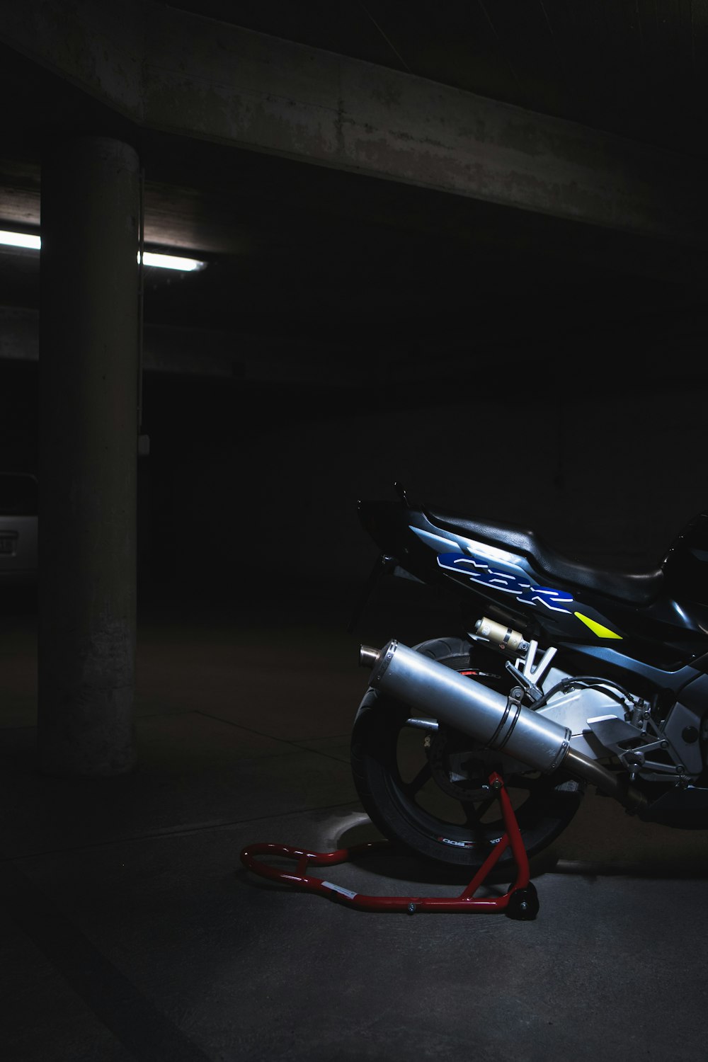 black motorcycle parked beside gray post