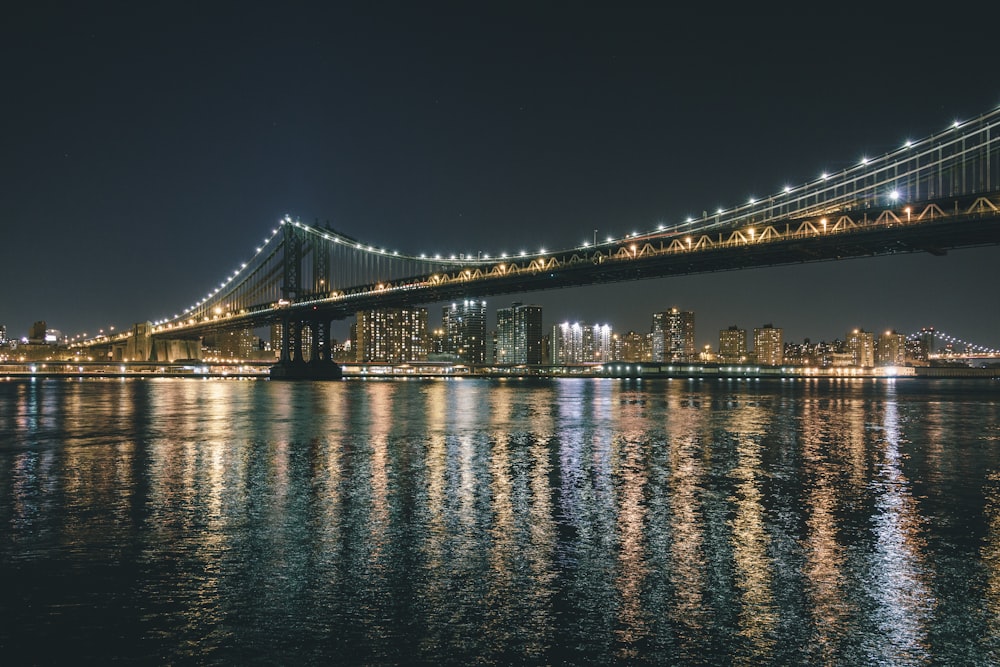 lighted bridge over water during night time