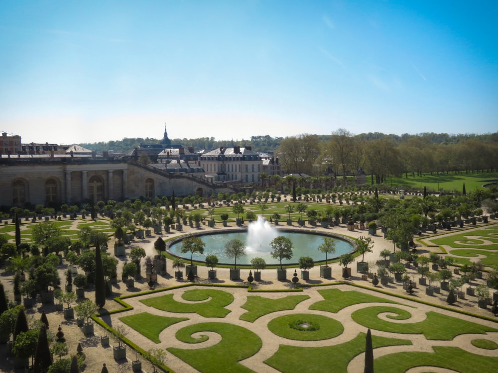 campo di erba verde con fontana durante il giorno