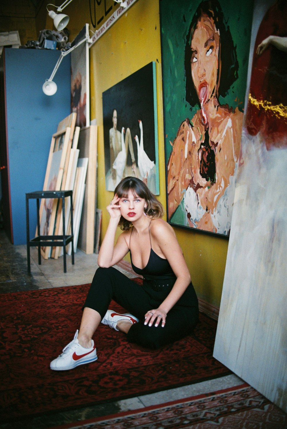 woman in black tank top and black shorts sitting on brown wooden chair