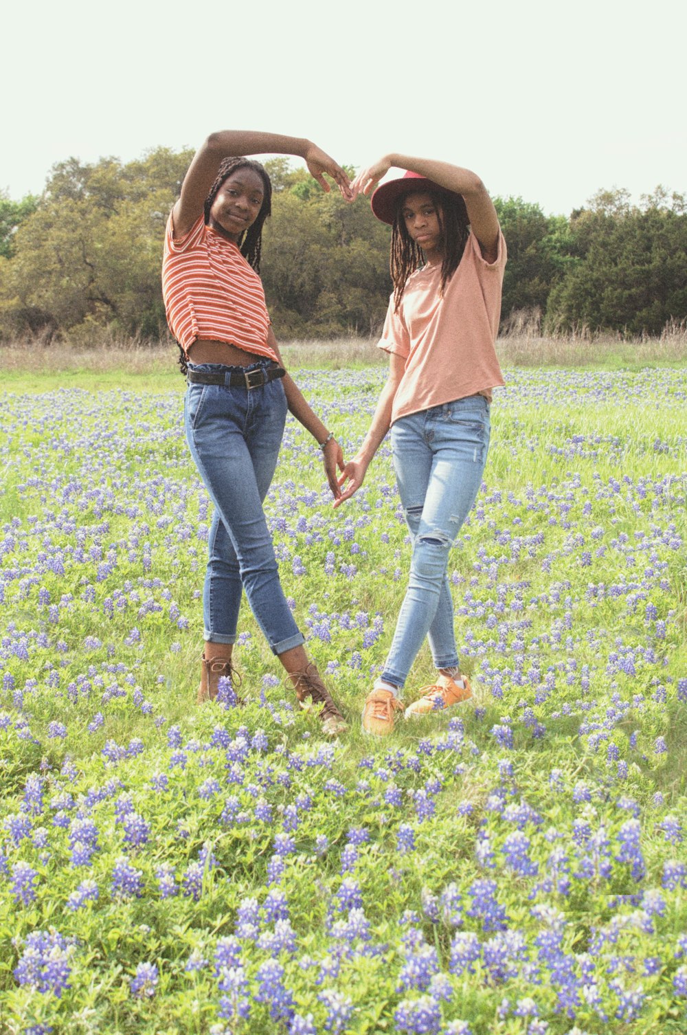 woman in brown long sleeve shirt and blue denim jeans standing on green grass field during