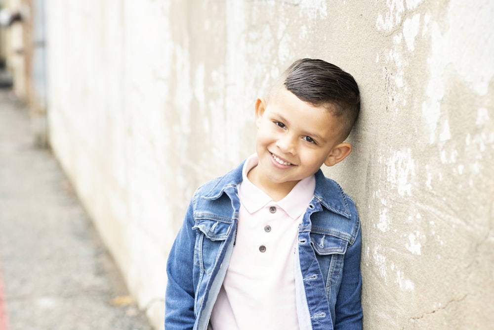 girl in blue denim jacket leaning on wall