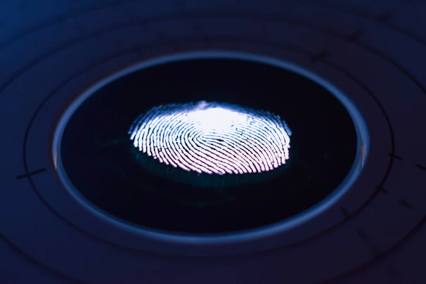 A close-up of a technician carefully scanning fingerprints in a bright, professional office.