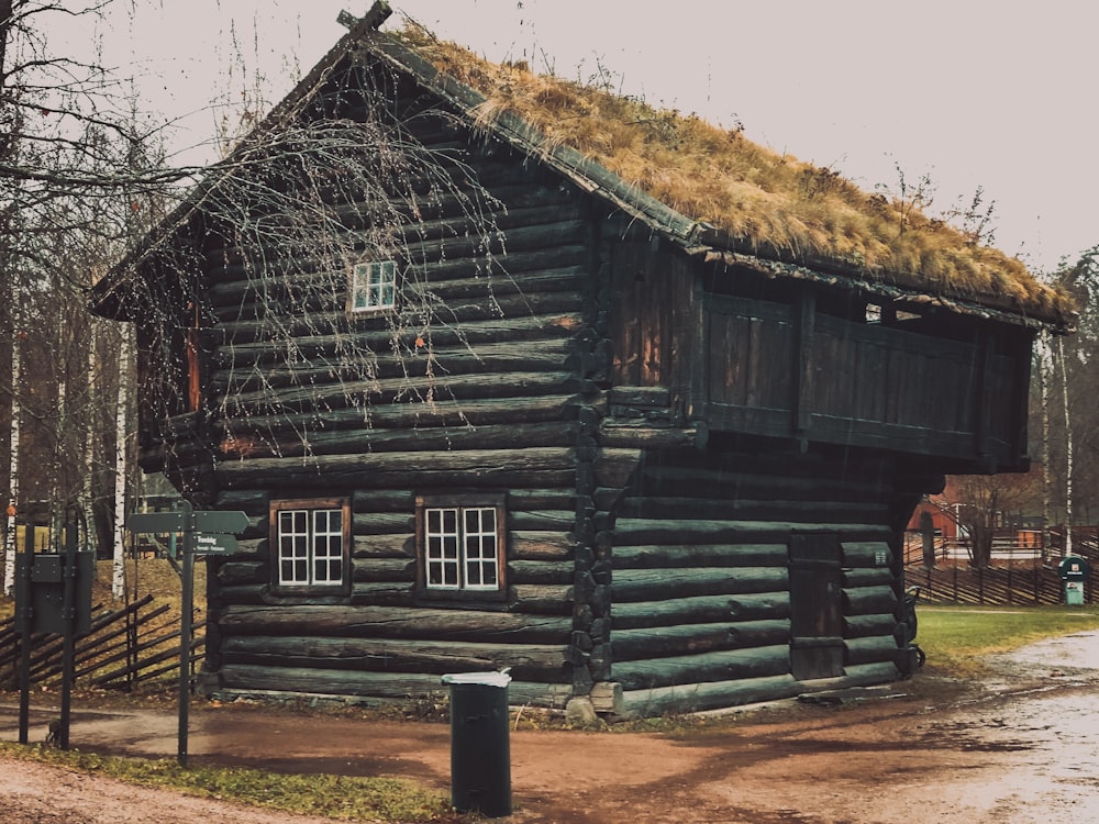 brown wooden house near bare trees during daytime