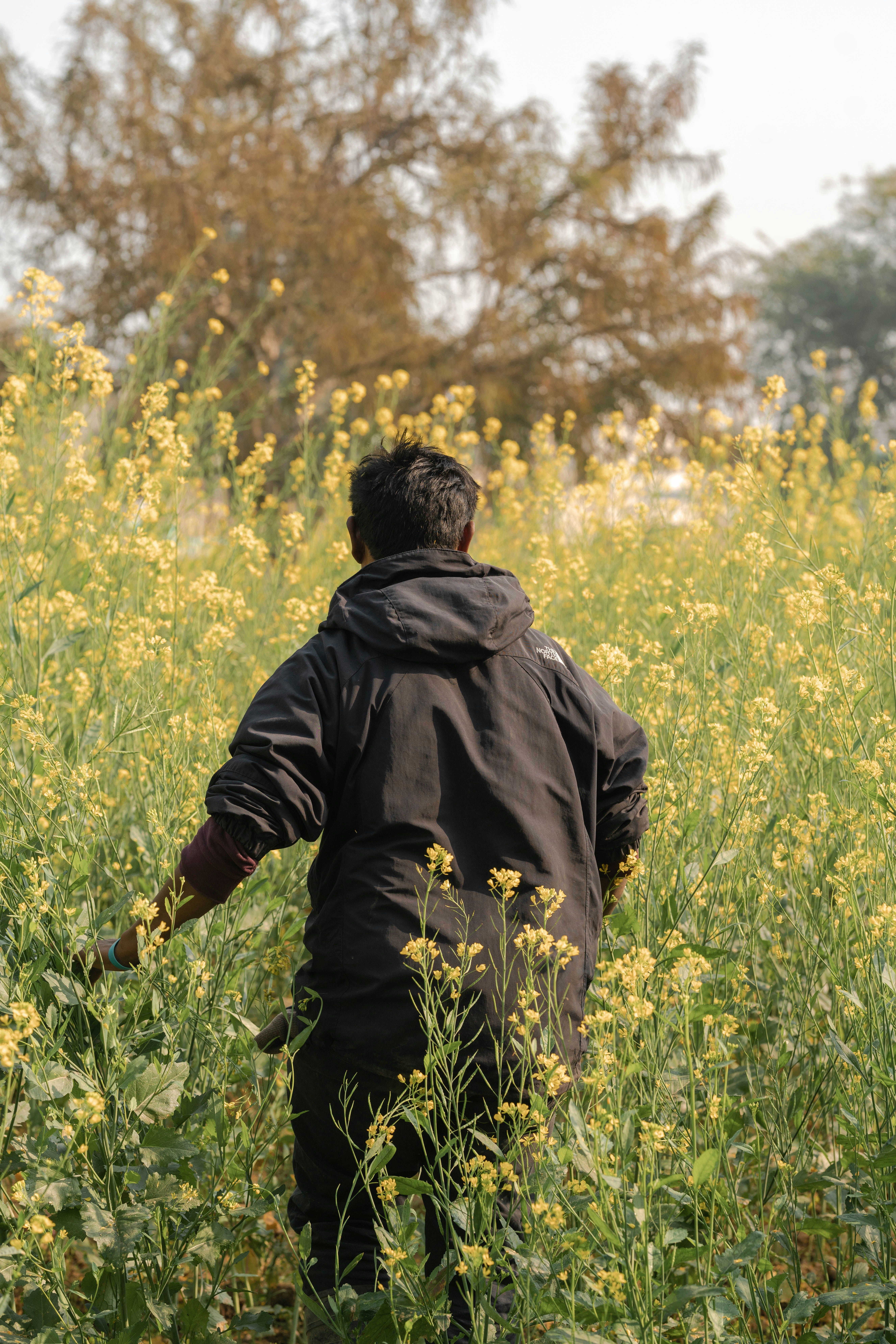 man in black hoodie standing on green grass field during daytime