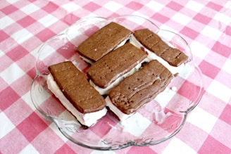 A playful arrangement of colorful ice cream sandwiches stacked on a rustic wooden board