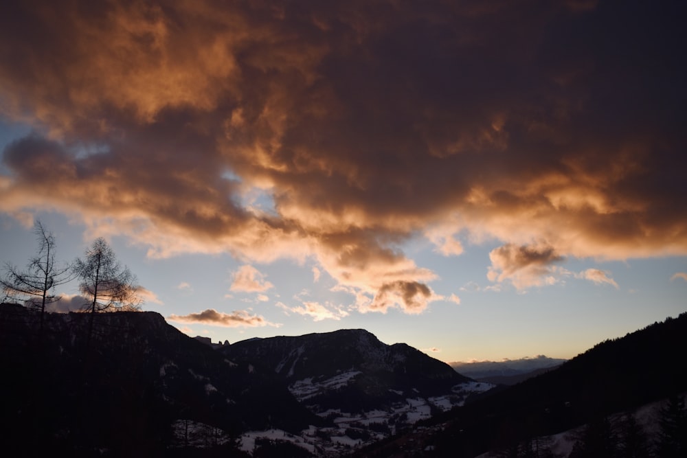 montagne coperte di neve sotto il cielo nuvoloso durante il giorno