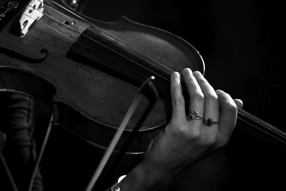 person playing violin in grayscale photography