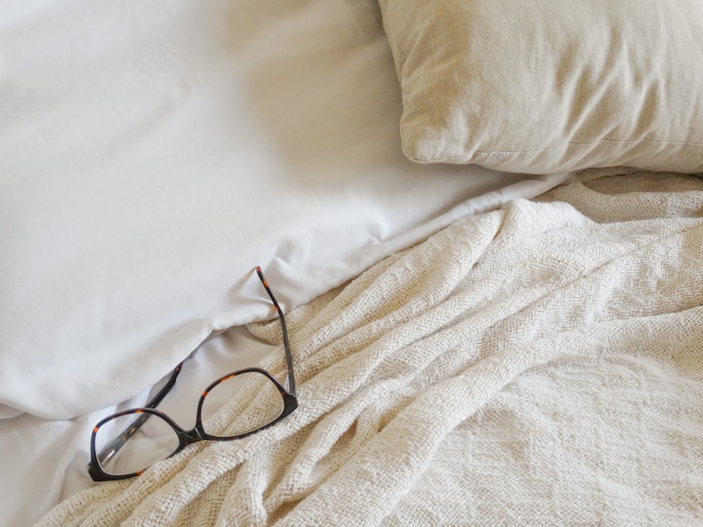 black framed eyeglasses on white textile