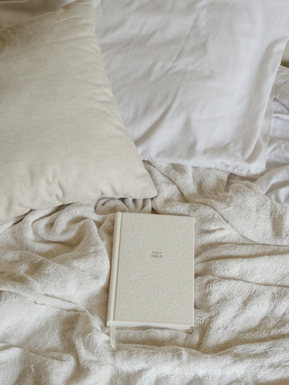 a book and some pillows on a bed