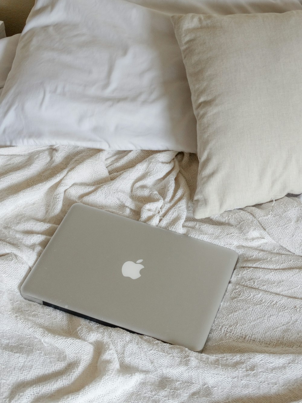 silver macbook on white textile