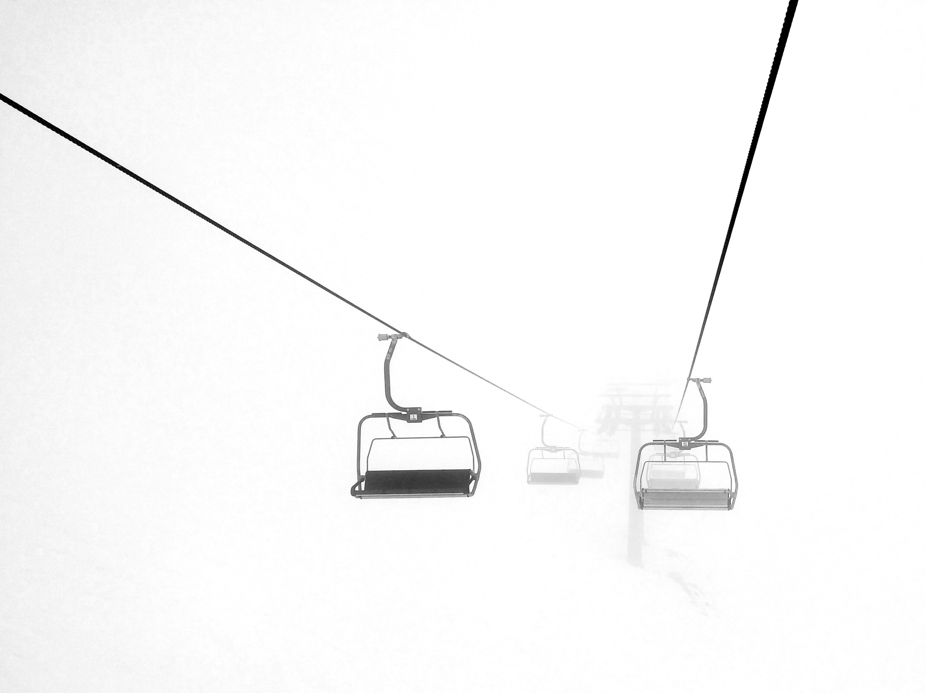 Chairlift in foggy weather.