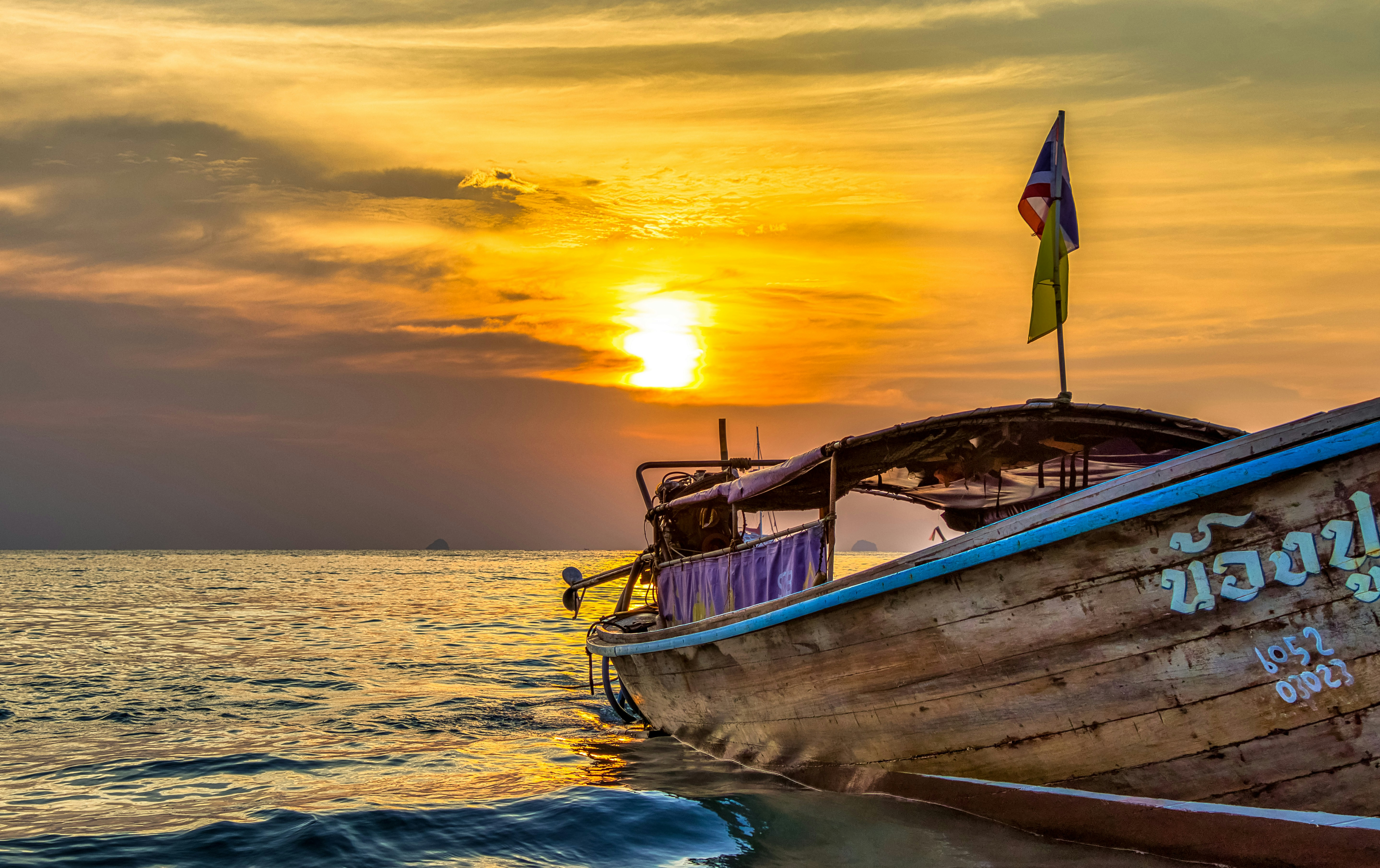 white and brown boat on sea during sunset