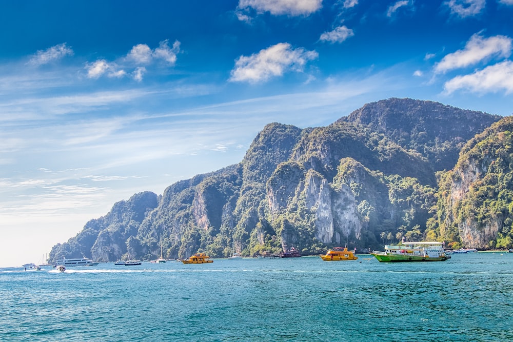 green and brown mountain beside body of water during daytime