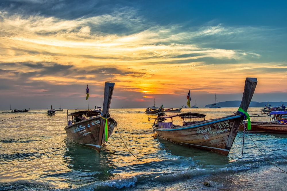 white and blue boat on sea during sunset