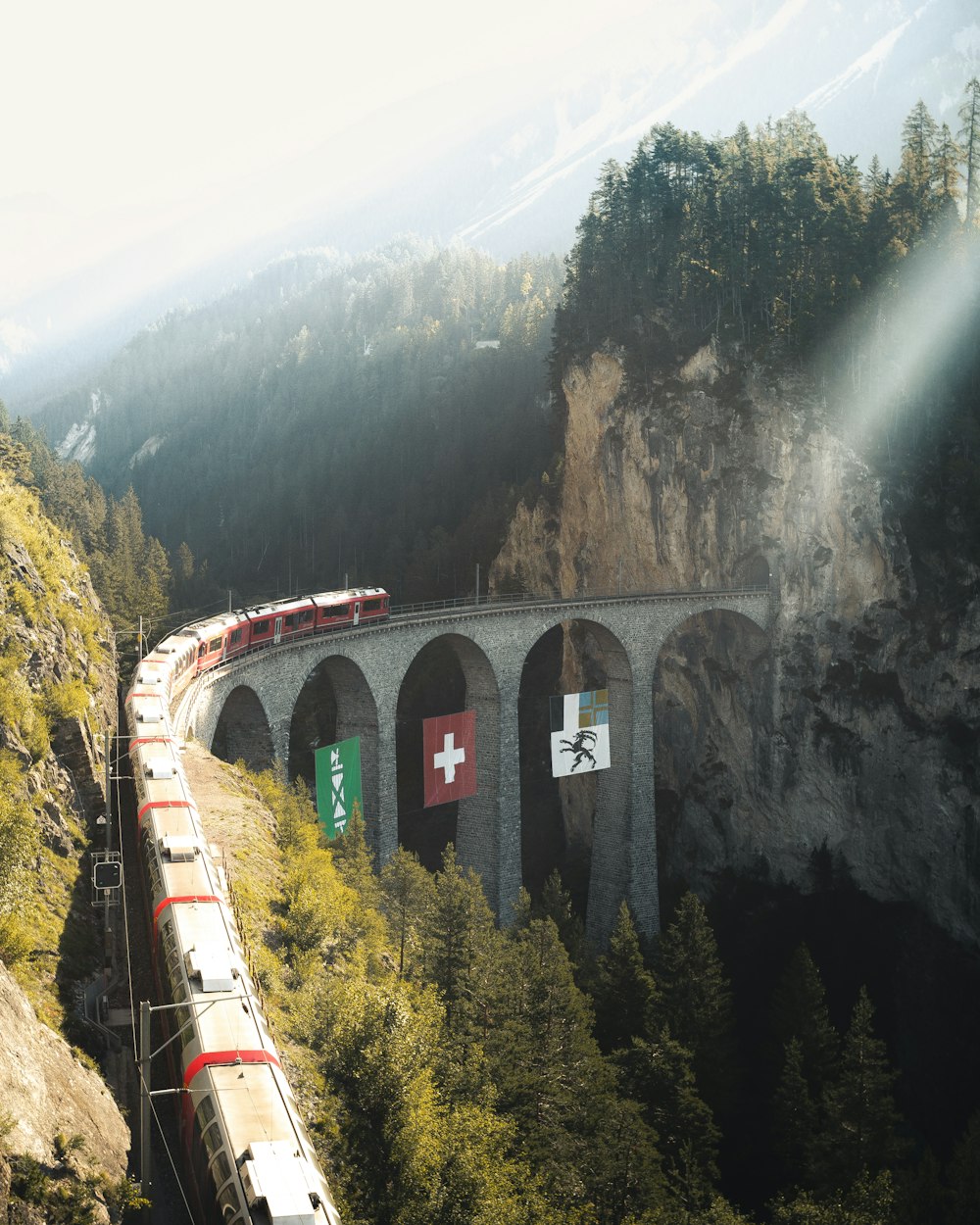 낮 동안 산 근처의 철도에 빨간 기차