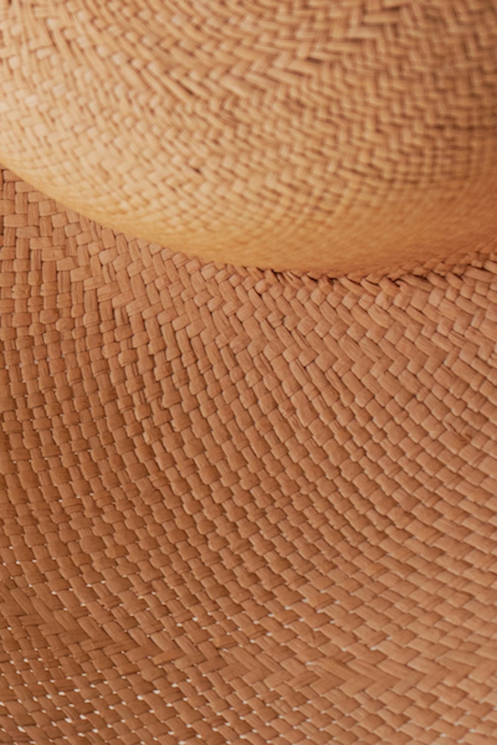 chapeau tissé marron sur textile blanc