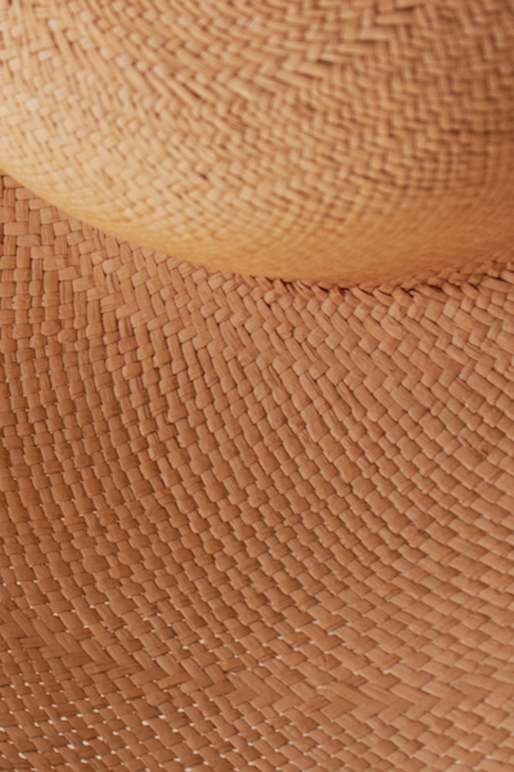 brown woven hat on white textile