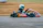 Savannah Maddox mid-race, helmet on and focused, kart leaning into a swift curve